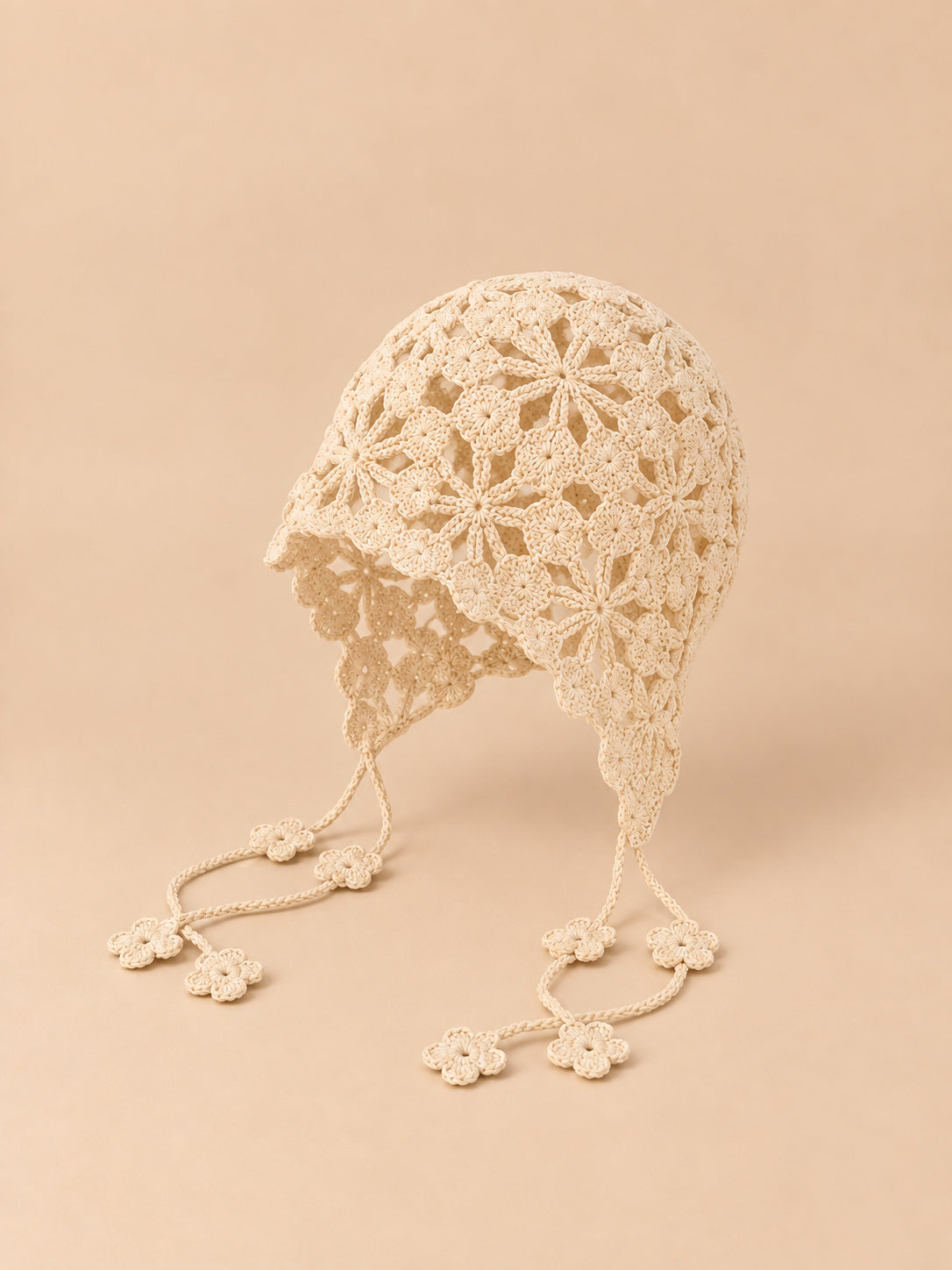 Bonnet au crochet ajouré beige à nouer, vue de trois quarts