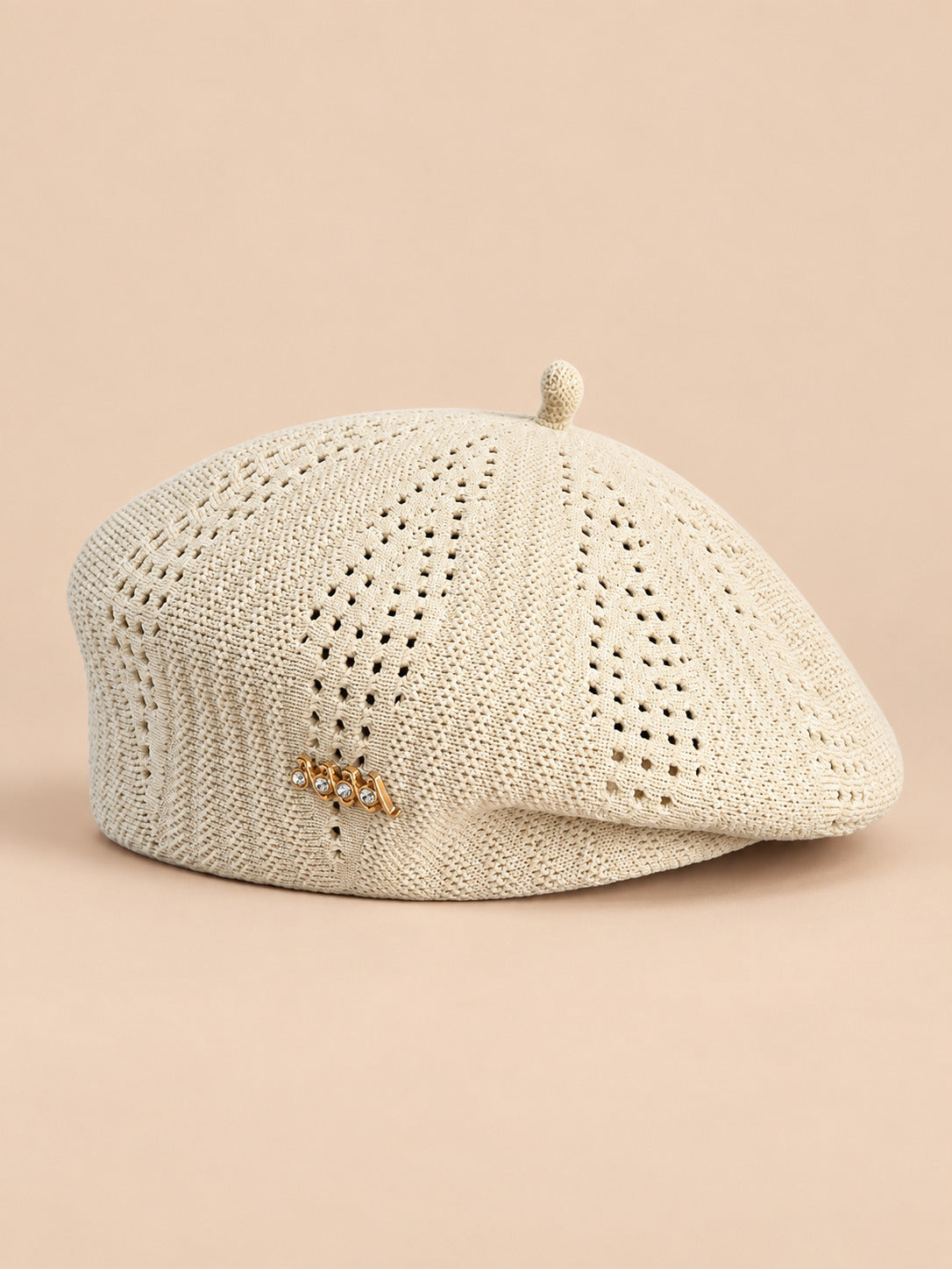 Béret ajouré style japonais beige, vue de face sur fond pêche sable