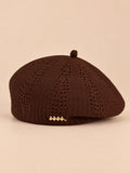 Béret ajouré style japonais marron, vue de face sur fond pêche sable