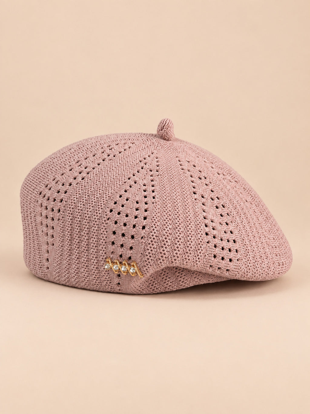 Béret ajouré style japonais rose, vue de face sur fond pêche sable