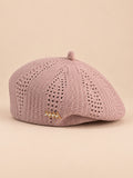 Béret ajouré style japonais rose, vue de face sur fond pêche sable