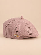 Béret ajouré style japonais rose, vue de face sur fond pêche sable