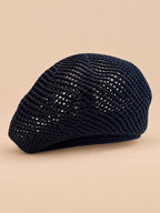 Béret d’artiste ajouré noir, vue de face sur fond pêche sable