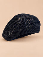 Béret d’artiste ajouré noir, vue de trois quarts sur fond pêche sable