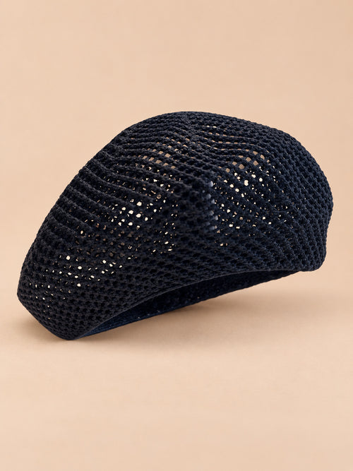 Béret d’artiste ajouré noir, vue de trois quarts sur fond pêche sable