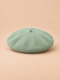 Béret d’artiste femme en laine mélangée vintage, coloris 008, vue de face sur fond sable pêche.
