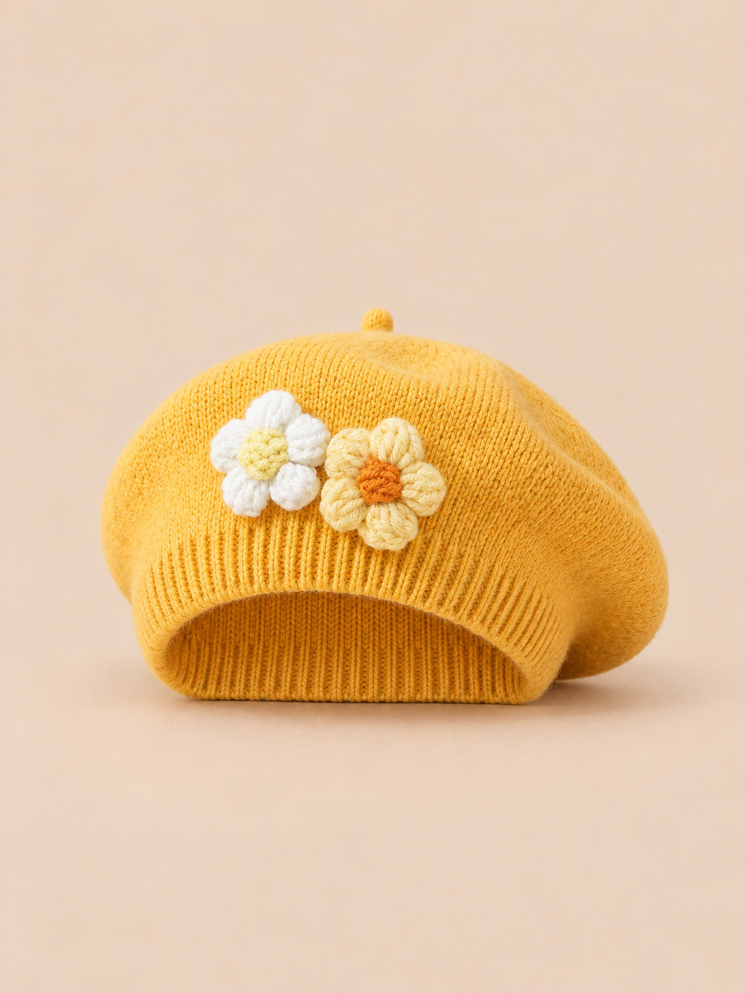 Béret bébé fille Jaune à fleurs en relief au crochet, vue de face sur fond pêche sable