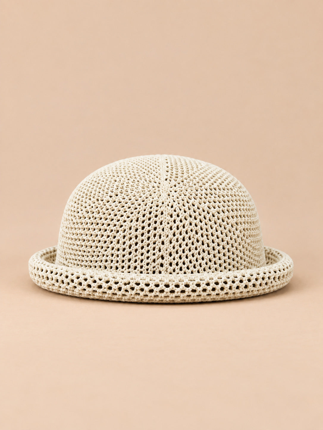 Béret bibi ajouré beige, vue de face sur fond pêche sable