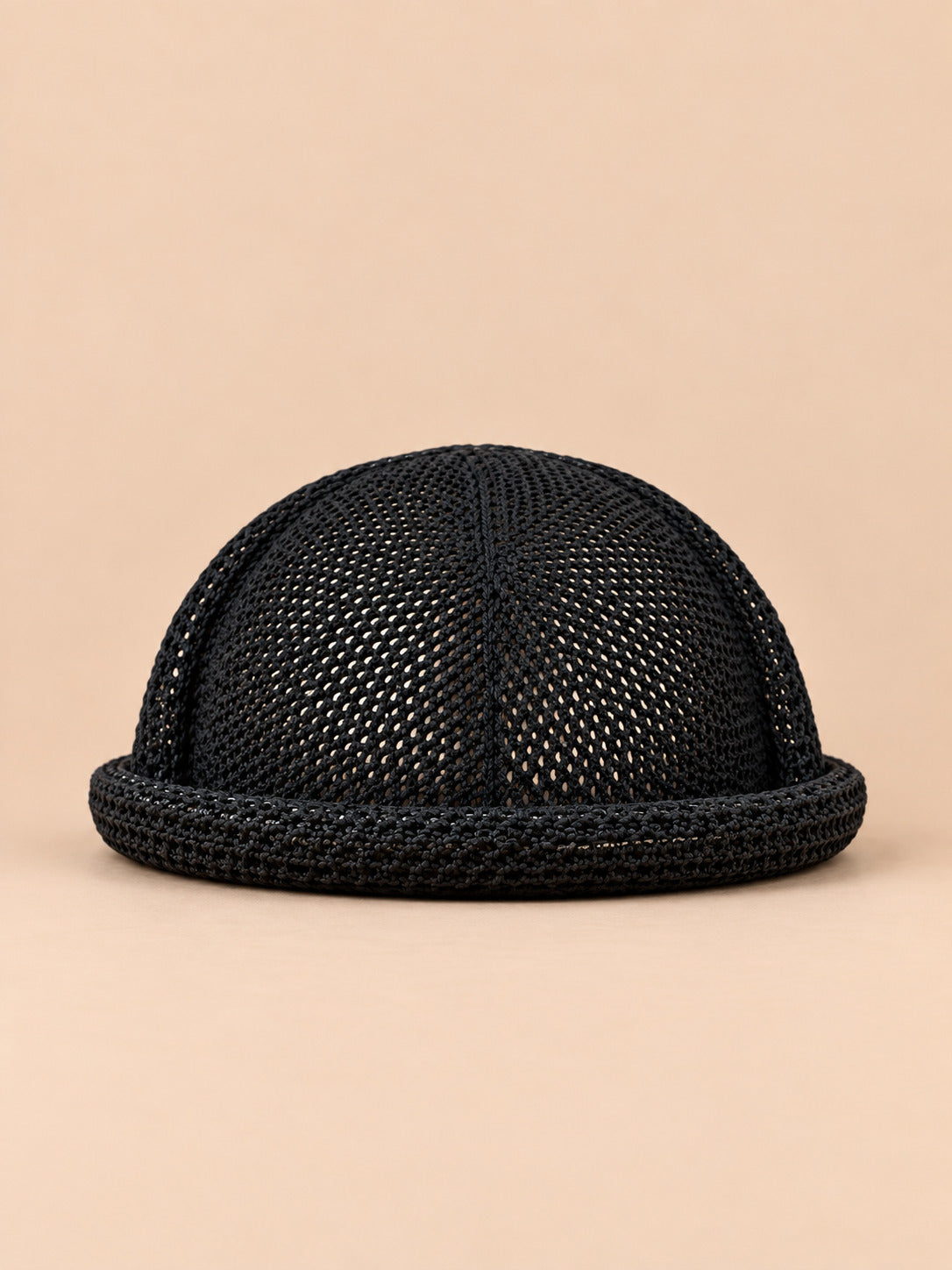 Béret bibi ajouré noir, vue de face sur fond pêche sable