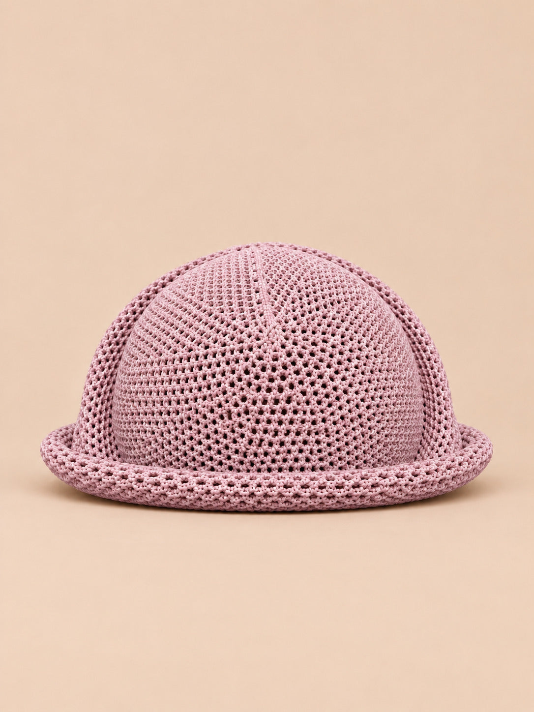 Béret bibi ajouré rose, vue de face sur fond pêche sable