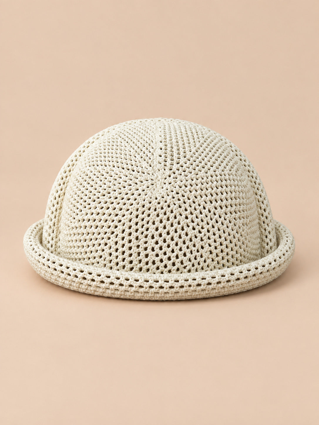 Béret bibi résille beige, vue de face sur fond pêche sable