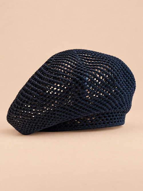 Béret bibi résille bleu nuit, vue de trois quarts sur fond pêche sable