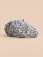 Béret citrouille ajouré gris, vue de face sur fond pêche sable