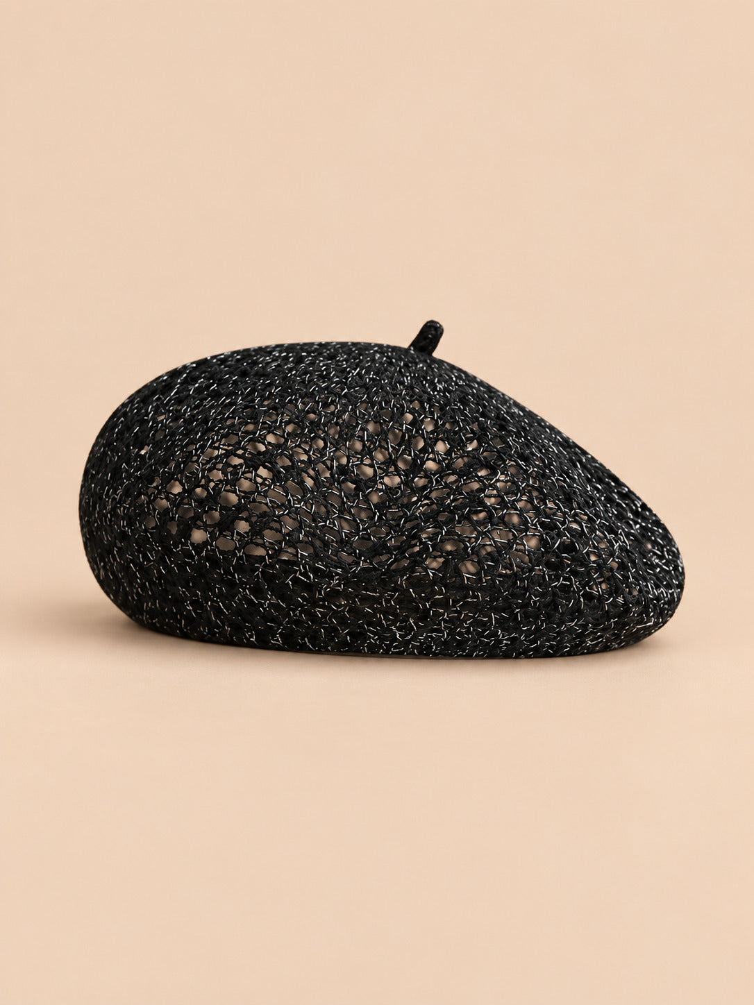 Béret citrouille ajouré noir, vue de face sur fond pêche sable