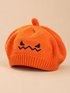 Béret enfant citrouille orange en maille avec visage brodé, vue de trois quarts