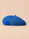 Béret d’été en lin ajouré bleu, vue de face sur fond pêche sable