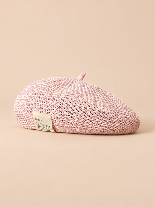 Béret d’été en lin ajouré rose, vue de trois quarts sur fond pêche sable