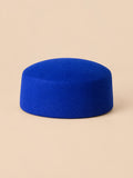 Béret femme en laine feutrée bleu, forme plat, vue de face sur fond pêche sable