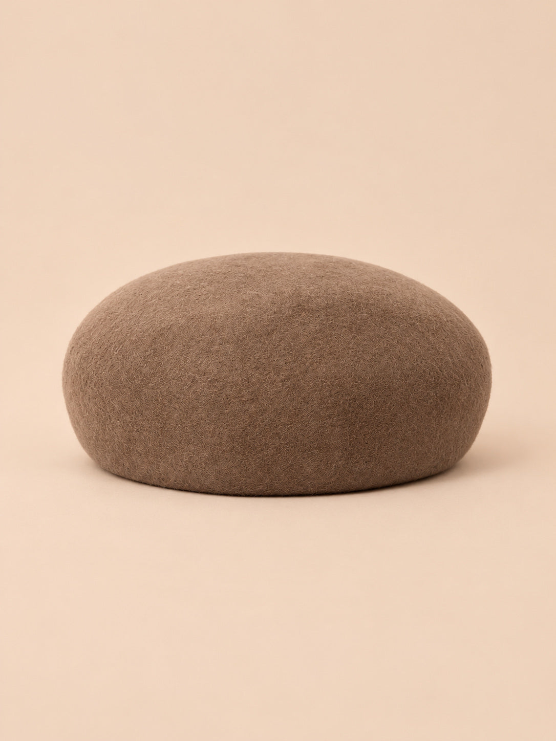 Béret femme en laine feutrée kaki, forme rond, vue de face sur fond pêche sable