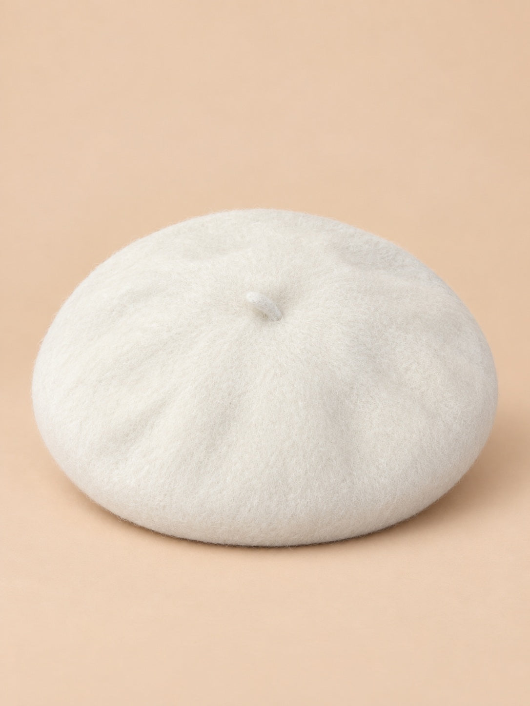 Béret français femme en pure laine blanc, vue de face sur fond beige