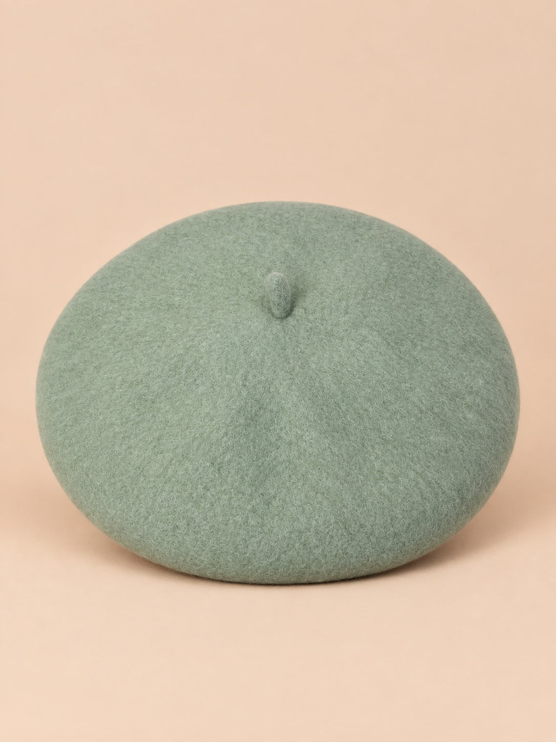 Béret français femme en pure laine vert clair, vue de face sur fond beige