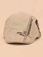 Béret gavroche en coton kaki, vue de face sur fond pêche sable