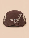 Béret gavroche en coton marron, vue de face sur fond pêche sable