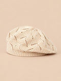 Béret plat ajouré beige, vue de face sur fond pêche sable