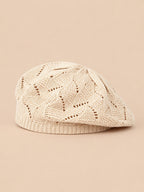Béret plat ajouré beige, vue de face sur fond pêche sable