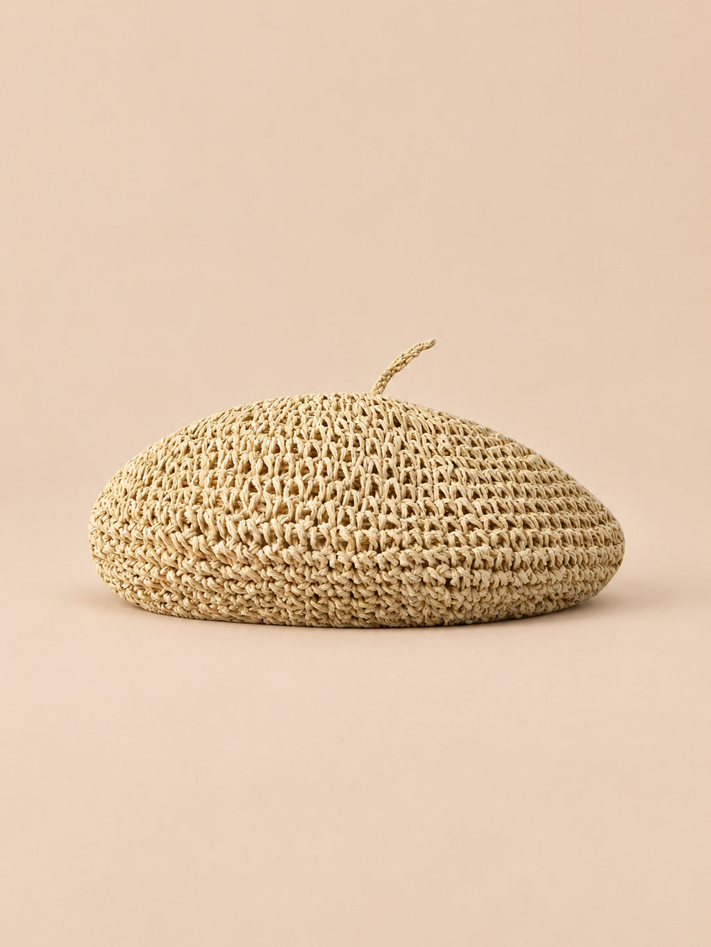 Béret plat effet paille Beige, vue de face sur fond pêche sable