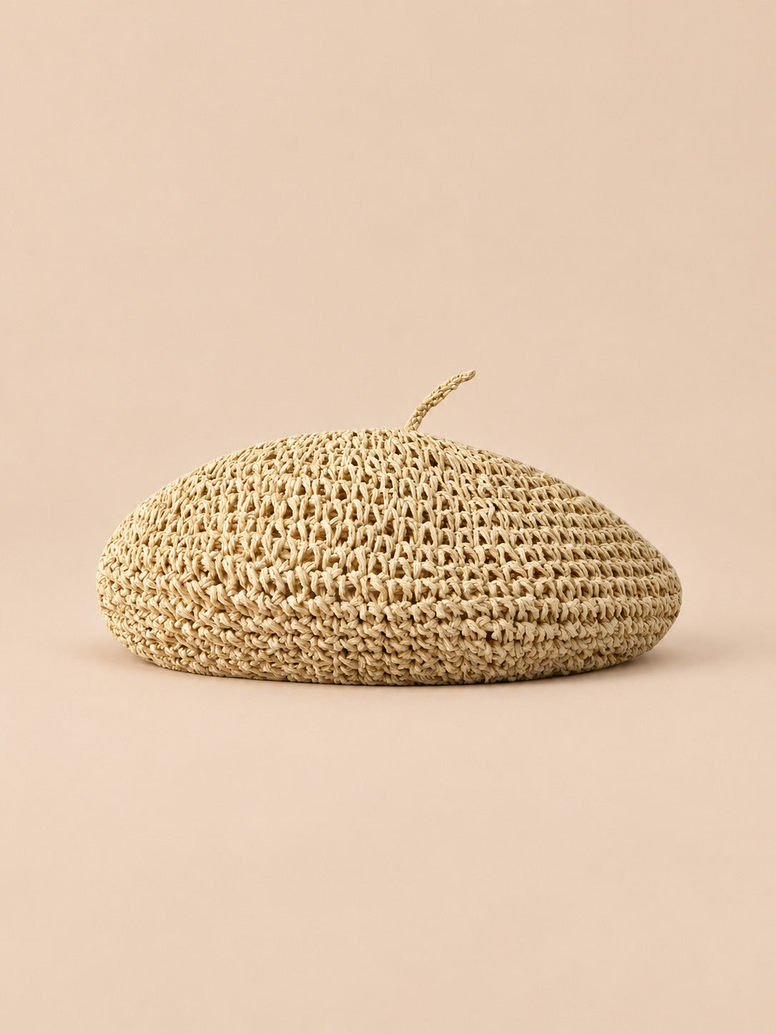 Béret plat effet paille Beige, vue de face sur fond pêche sable