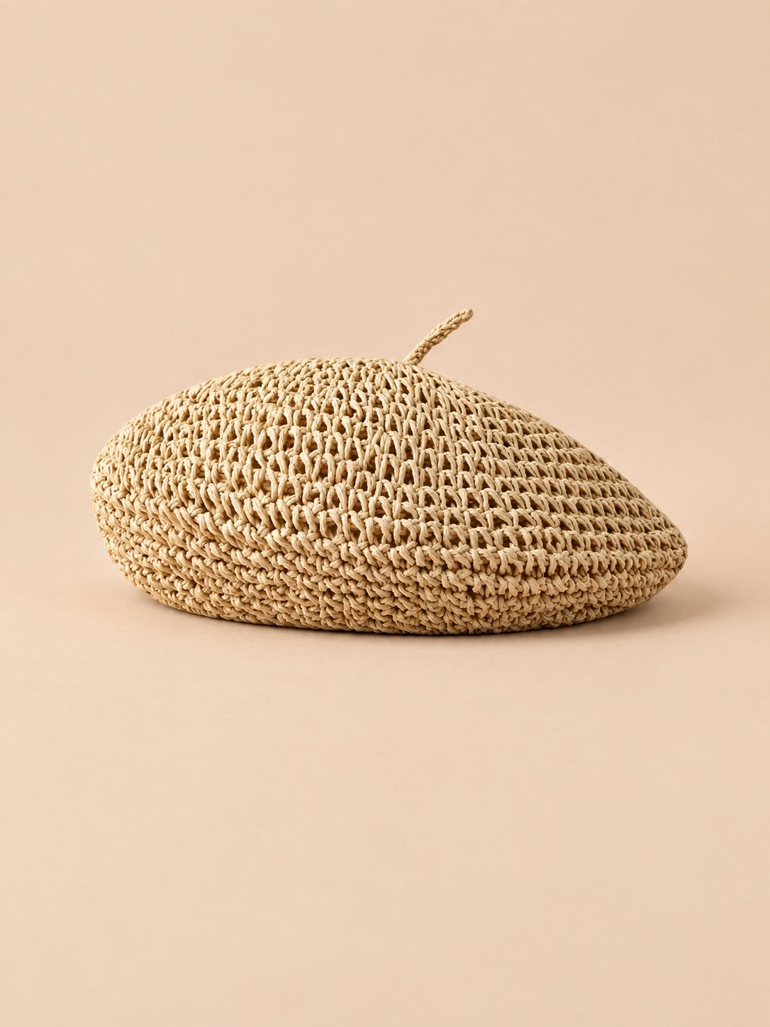 Béret plat effet paille Beige, vue de trois quarts sur fond pêche sable