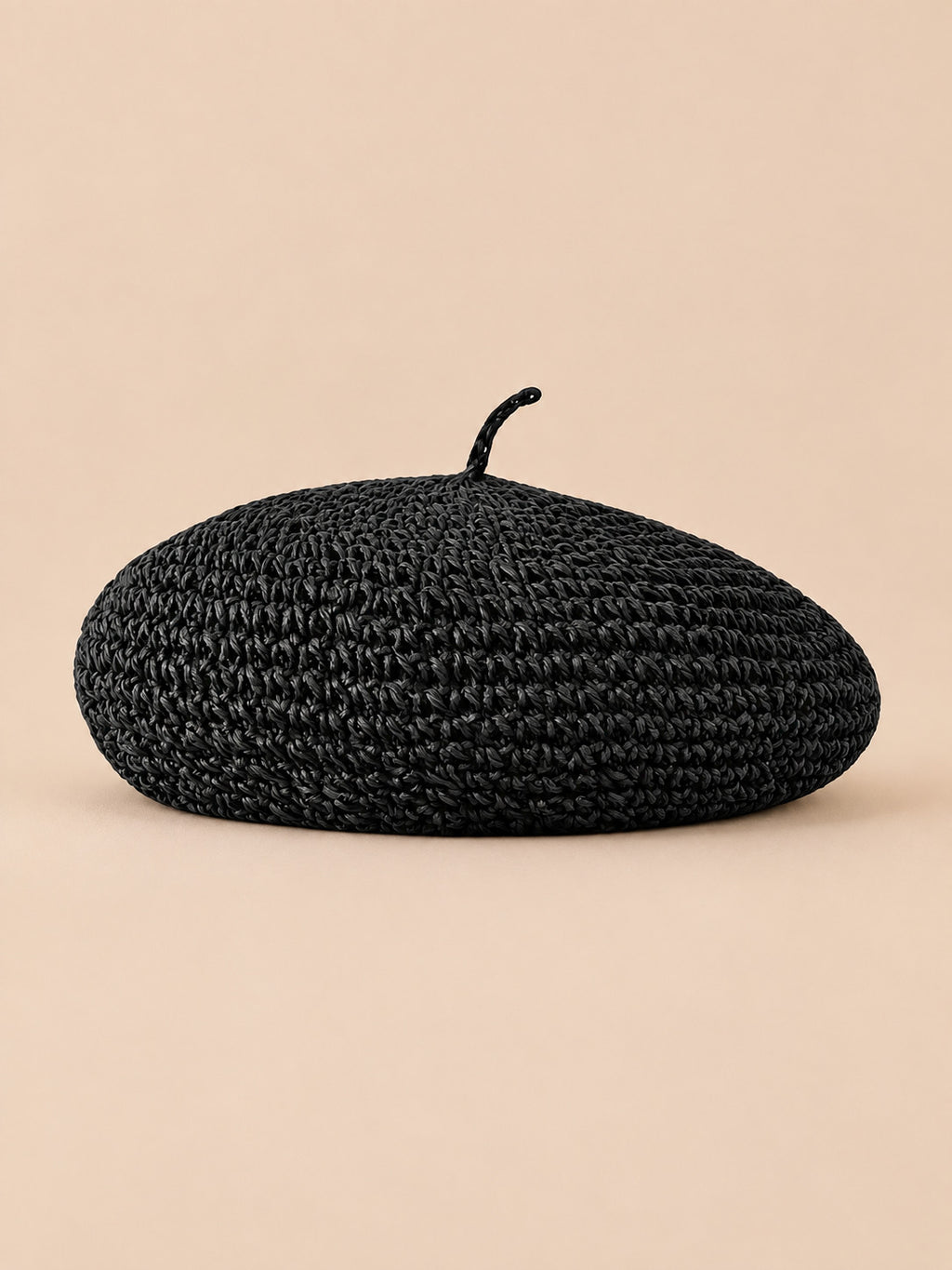 Béret plat effet paille Noir, vue de face sur fond pêche sable