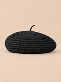 Béret plat effet paille Noir, vue de face sur fond pêche sable