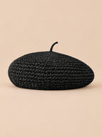 Béret plat effet paille Noir, vue de face sur fond pêche sable
