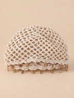 Béret rétro beige ajouré au crochet à franges d'étoiles dorées, vue de face sur fond pêche sable