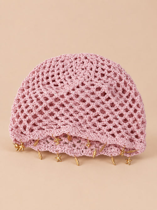 Béret rétro rose ajouré au crochet à franges d'étoiles dorées, vue de face sur fond pêche sable