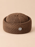 Béret rétro crochet Marron M, vue de face sur fond pêche sable