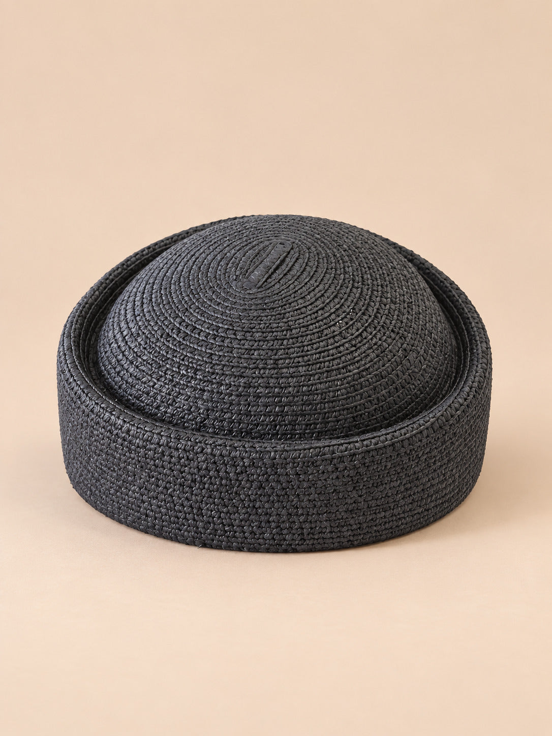 Béret rétro crochet Modèle 3 noir, vue de face sur fond pêche sable