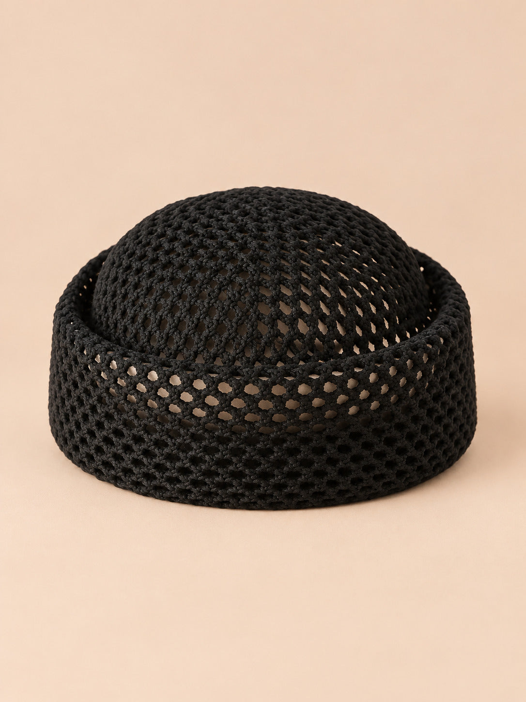 Béret rétro crochet Noir, vue de face sur fond pêche sable