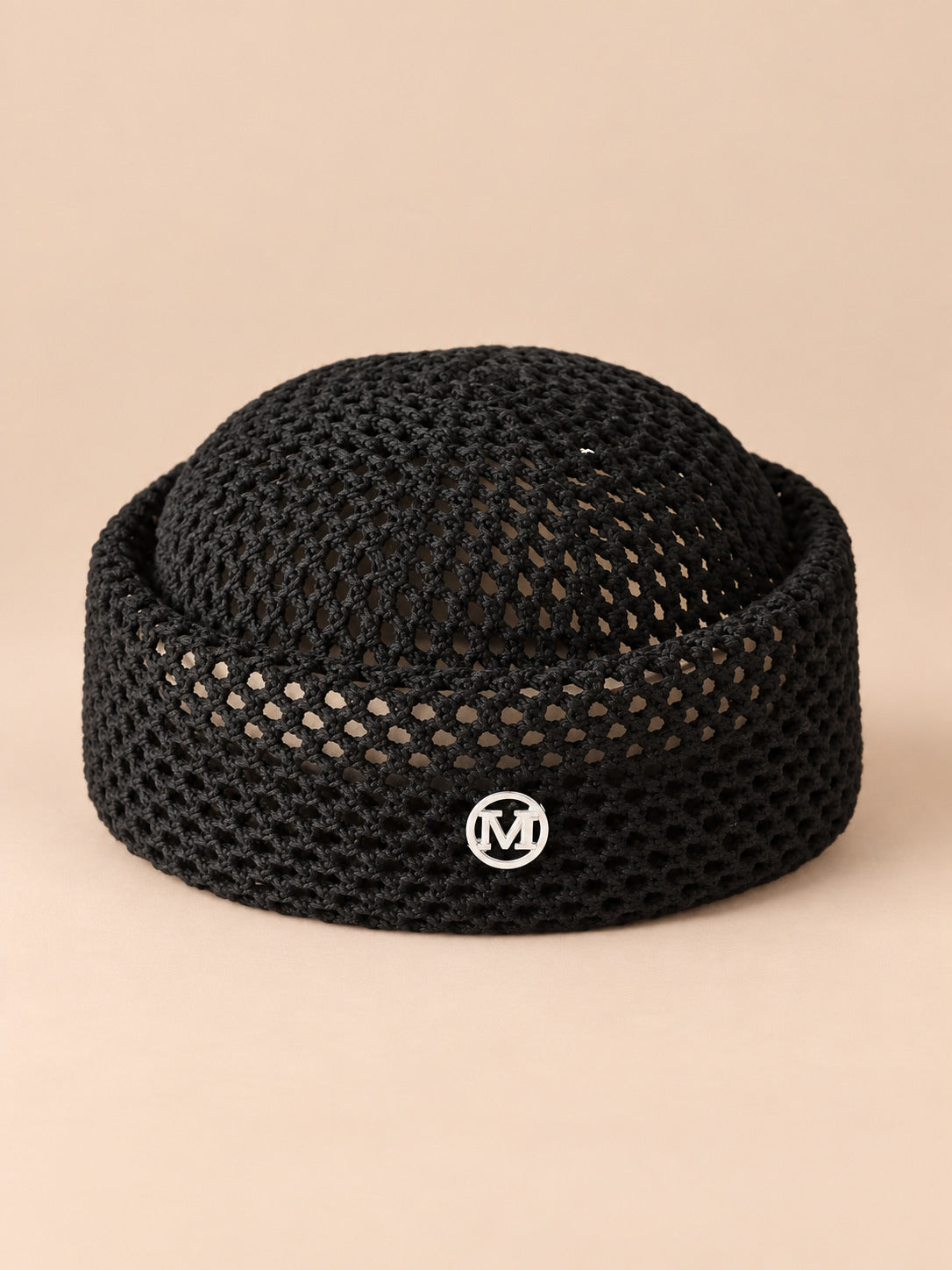 Béret rétro crochet Noir M, vue de face sur fond pêche sable