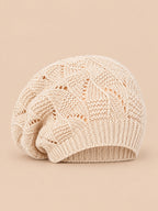 Bonnet béret torsadé ample beige, vue de face sur fond pêche sable