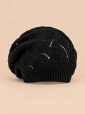 Bonnet béret torsadé ample noir, vue de face sur fond pêche sable