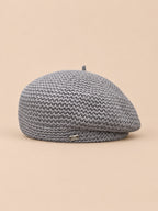 Béret tricoté ajouré léger Gris, vue de face sur fond pêche sable
