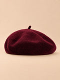 Béret uni femme en maille chaude bordeaux, vue de face sur fond beige
