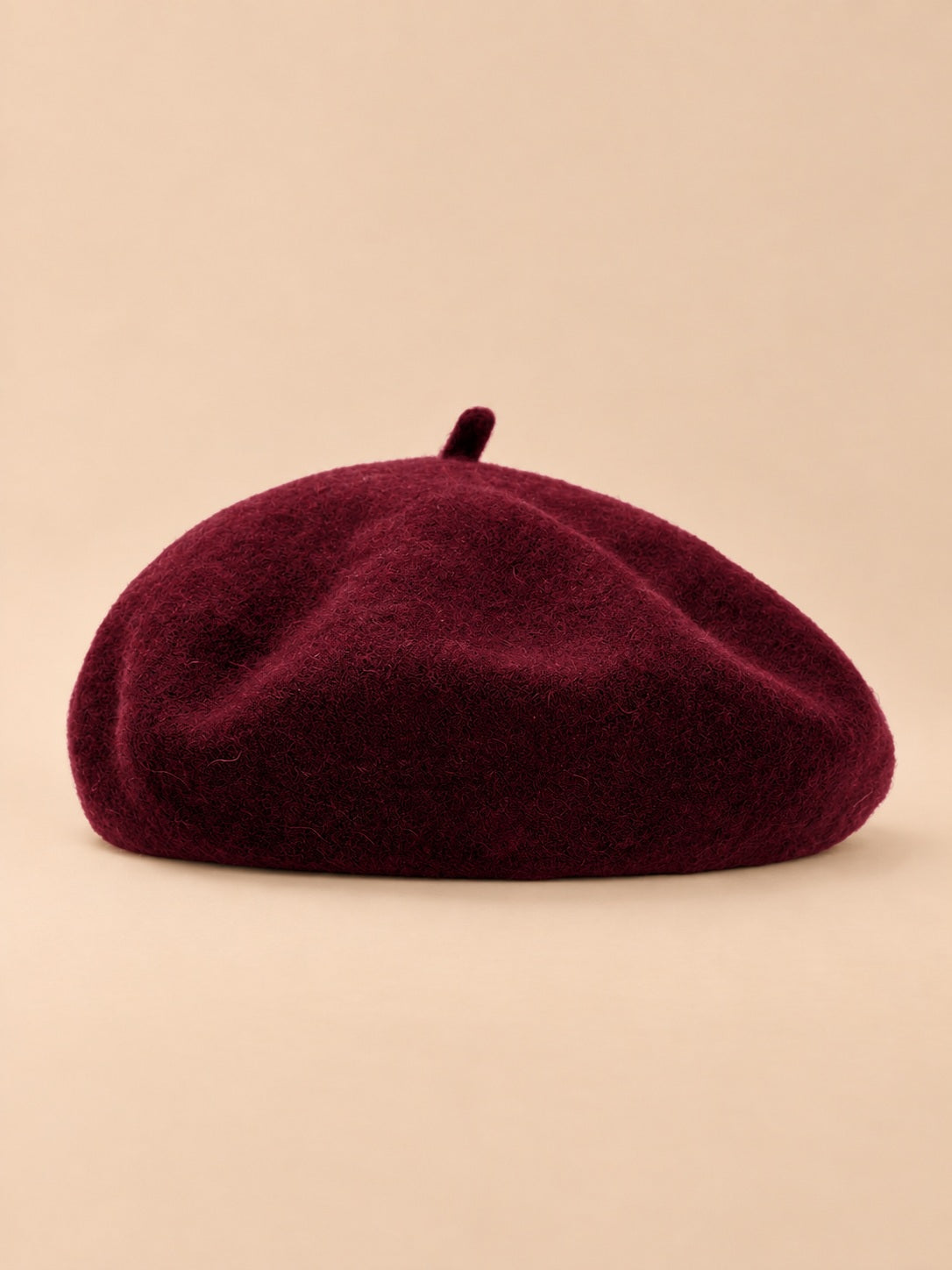 Béret uni femme en maille chaude bordeaux, vue de face sur fond beige