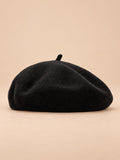 Béret uni femme en maille chaude noir, vue de face sur fond beige