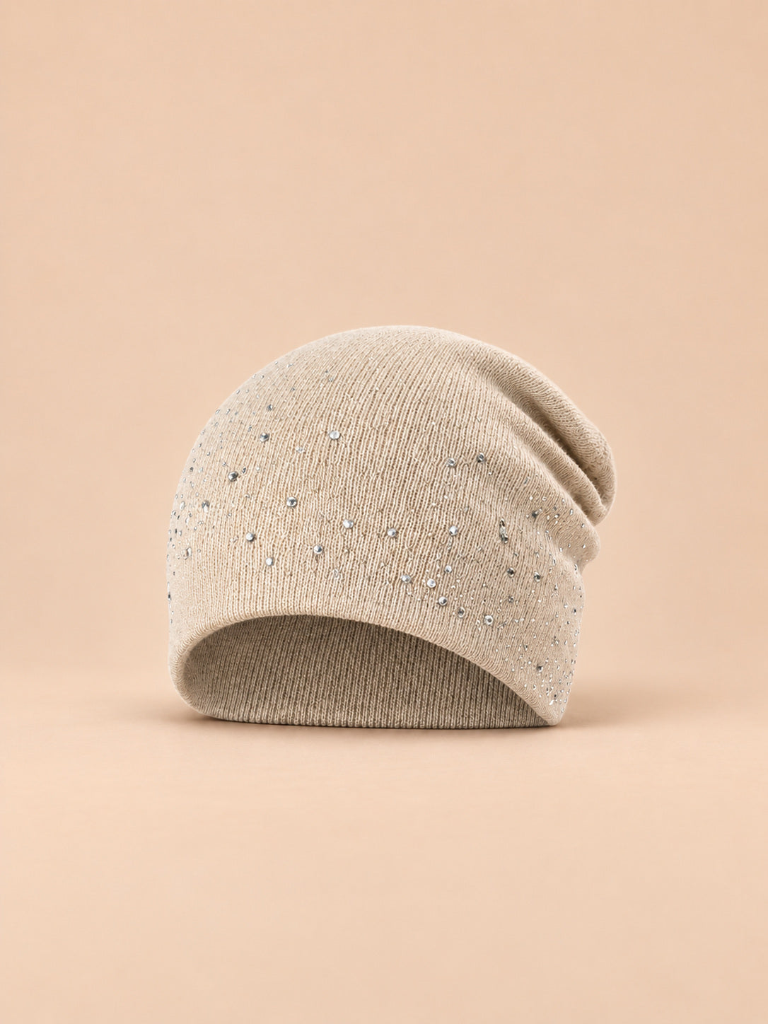 Bonnet femme tricoté à strass beige, vue de face sur fond pêche sable