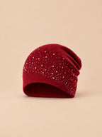 Bonnet femme tricoté à strass bordeaux, vue de face sur fond pêche sable