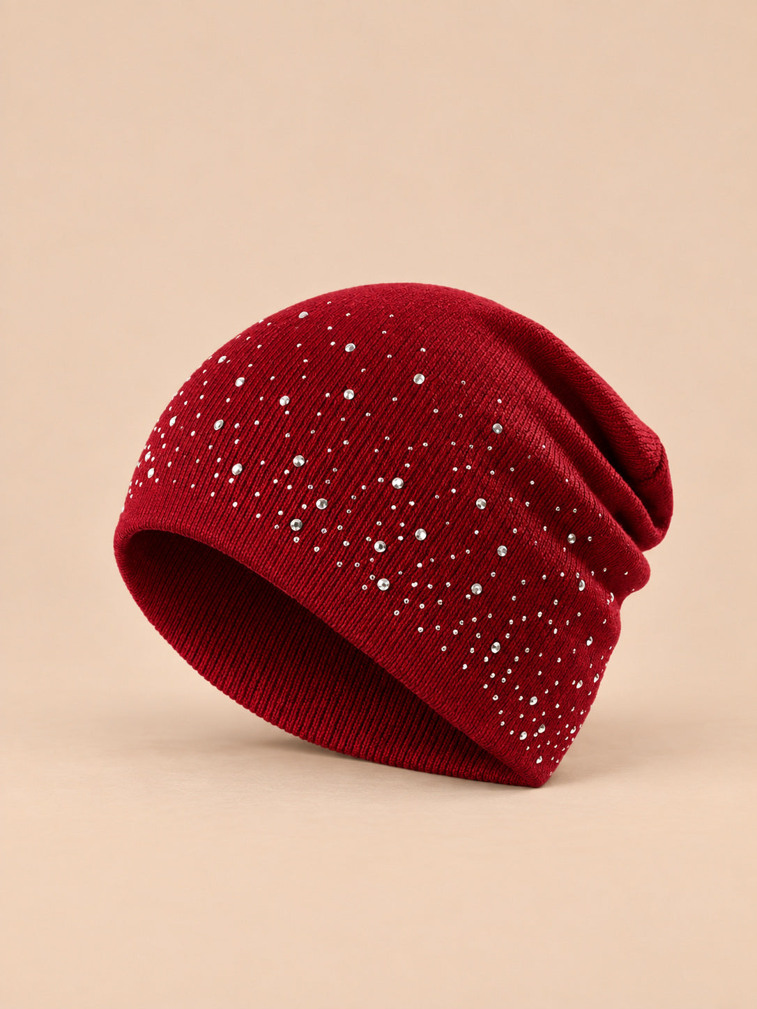 Bonnet femme tricoté à strass bordeaux, vue de trois-quarts sur fond pêche sable